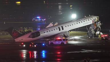 Emergency crews work around an Air Canada Express jet that had collided with a ground vehicle at New York's La Guardia Airport in Queens, New York. Reuters