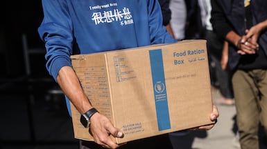A man carries a box of food from the World Food Programme at a distribution centre in the village of Al Zawayda, central Gaza. AFP