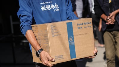 A man carries a box of food from the World Food Programme at a distribution centre in the village of Al Zawayda, central Gaza. AFP