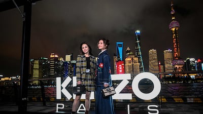 From left: Hong Kong singers Gillian Chung and Charlene Choi pose on the red carpet ahead of the Kenzo fashion show at the North Bund Bay in Shanghai. All photos: AFP