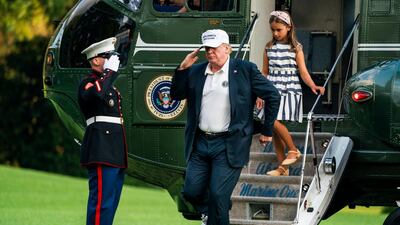US President Donald Trump and his granddaughter walk off Marine One as they return from a weekend stay in Bedminster, New Jersey. Jim Lo Scalzo / EPA