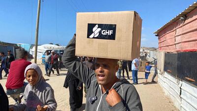 Displaced Palestinians receive food packages from a US-backed foundation pledging to distribute humanitarian aid in western Rafah. AFP