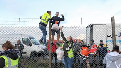 Volunteers distribute fresh food and supplies over a perimeter fence to truck drivers at Manston airport in Manston, U.K. Routes to Dover, Britain's busiest cross-channel port, have been choked for days after France shut its border with Britain, blaming an outbreak of a novel strain of the coronavirus. Bloomberg