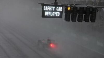 A car passes by a warning signal during heavy rainfall at the race. Paulo Whitaker / Reuters