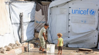 A Palestinian child collects water at a displacement camp in Gaza city, as Israeli proposals to relocate the entire population of the strip resurfaced. Reuters