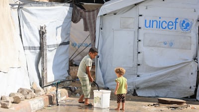 A Palestinian child collects water at a displacement camp in Gaza city, as Israeli proposals to relocate the entire population of the strip resurfaced. Reuters