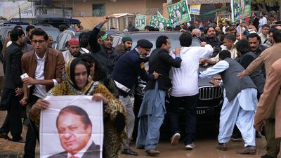 Supporters of ousted Pakistani prime minister Nawaz Sharif surround Sharif's car as he arrives to appear before an accountability court to face corruption charges in Islamabad. Aamir Qureshi / AFP Photo