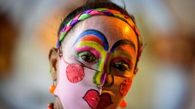 A street artist wears a painted protective facemask to match her makeup in Bangkok. AFP