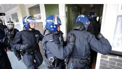 London police officers carry out a raid on a property in Pimlico, London, hoping to recover property stolen during the capital riots.