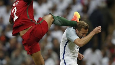 Portugal defender Bruno Alves, left, was shown a straight red card for this head-high challenge on England's Harry Kane during an international friendly at Wembley in June. Adrian Dennis / AFP