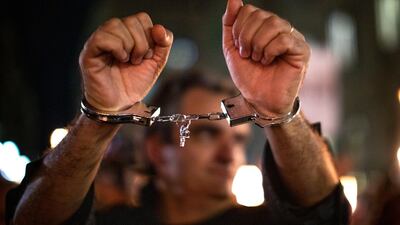 A Catalan pro-independence protester shows handcuffs during a demonstration in Barcelona, Spain. AP Photo