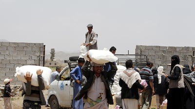 Conflict-affected Yemenis receive their families' food supplies at a neighborhood in Sana'a, Yemen, 09 May 2018. EPA/YAHYA ARHAB