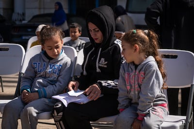 A mother and children wait to be attended by the Red Cross at Camille Chamoun Sports City Stadium in Beirut. Getty Images