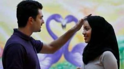 Emad Qanaq, left, adjusts the veil of his wife Ayat Ahmad, at the garden of their home in Riyadh, Saudi Arabia.