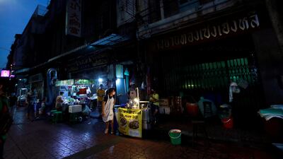 Vendors wearing protective masks sell food in Chinatown at night. Reuters