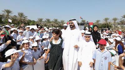Sheikh Mohammed bin Rashid and his daughter Sheikha Al Jalila are surrounded by tens of thousands of pupils as they walk through Zabeel Park during a flag-raising ceremony.