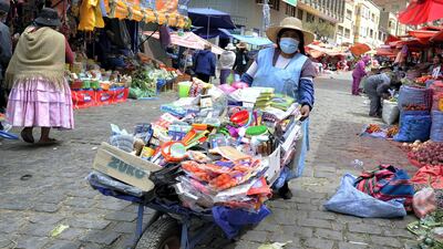 An Aymara indigenous woman wears a face mask as she offers cleaning products for sale at the Rodriguez Market in La Paz, Bolivia, on September 1, 2020, AFP