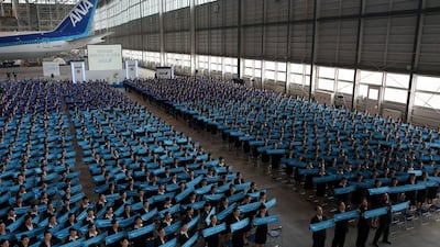 The welcome ceremony for new employees of ANA at its hangar in Tokyo. It is a custom for large Japanese corporations to hold mass welcoming ceremonies for their new employees. Chris McGrath / Getty Images