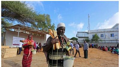 Abdi Hasan, 78, walking away with food for iftar from a charity in Mogadishu, Somalia on June 10, 2016. “We were worried before Ramadan started because we had no food. But now we are happy because we are getting bread, rice and juice for Ramadan breakfast and supper. Thank God,” Hasan says. Photo by Faisal Omar