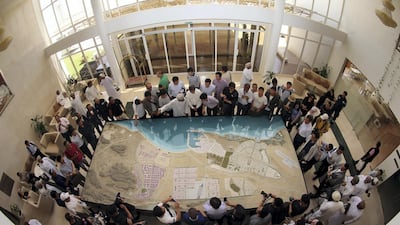 A picture taken with a fish-eye lens shows Chinese investors listening to an explanation as they check the model of the dry dock which is to be built following an economic agreement, on May 24, 2016 in the Omani port city of Duqm. Mohammed Mahjoub /AFP Photo
