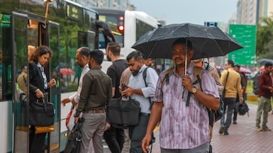 Commuters take cover during heavy rainfall in central Abu Dhabi on Monday morning. Victor Besa / The National