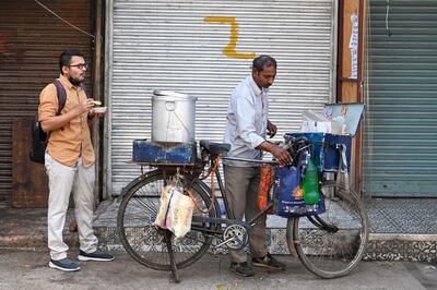 A food seller serves a customer at a market area in New Delhi. AFP