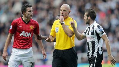 Referee Howard Webb tries to intervene between Robin Van Persie and Yohan Cabaye. Pic: Graham Stuart/AFP