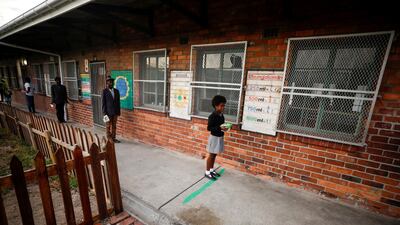 Learners observe social distancing markers as they queue at a school feeding scheme in in Cape Town, South Africa. Reuters