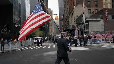An airline pilot carries an American flag during observances at the Ground Zero memorial site in New York. AFP