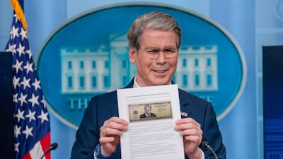 US Treasury Secretary Scott Bessent holds up a Washington Post article about a $250 bill with a portrait of US President Donald Trump. Reuters
