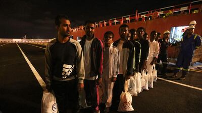 Migrants walk along the quay after disembarking from the vessel as they arrive to Zarzis harbour in the southern coast of Tunisia. AFP