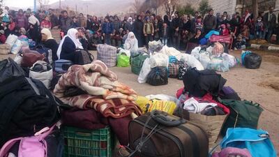 TOPSHOT - Syrians wait for the arrival of an aid convoy on January 11, 2016 in the besieged town of Madaya as part of a landmark six-month deal reached in September for an end to hostilities in those areas in exchange for humanitarian assistance. Forty-four trucks operated by the International Committee of the Red Cross, the Syrian Red Crescent, the United Nations and World Food Programme left from Damascus to enter Madaya, where more than two dozen people are reported to have starved to death. / AFP / Marwan IBRAHIM