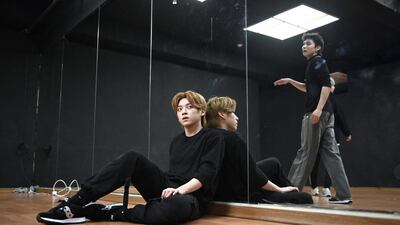 Blitzers member Jang Jun-ho, left, taking a break during a dance practise session at a rehearsal studio in Seoul. AFP