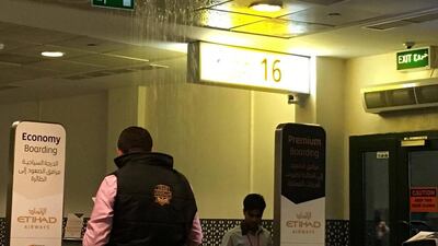 Rain water pours through the roof of a Abu Dhabi Airport's Terminal 1 departures gate Wednesday as severe weather moved through Abu Dhabi. The National