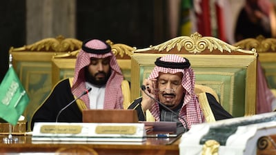 Saudi King Salman bin Abdulaziz, flanked by his son Crown Prince Mohammed bin Salman, puts on his spectacles as he prepares to read a document while chairing a session of the Gulf Cooperation Council summit. AFP / Fayez Nureldine