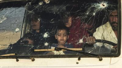Iraqi families escape the fighting in a bullet-strewn vehicle Makhmour and Qayyarah. Bulent Kilic / AFP Photo