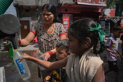 A family fills water bottles in New Delhi in May 2024. Getty Images