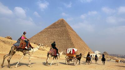 Tourists ride past the Giza pyramids on camels and in horse carts on the outskirts of Cairo on October 29, 2016. Mohamed Abd El Ghany/Reuters