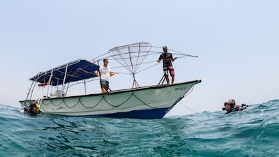 Divers deploy artificial reefs from a boat on Saturday