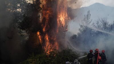 Firefighters from France extinguish a blaze that approached Neochori village in the Peloponnese, Greece, on August 12. Getty