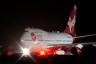 Cosmic Girl, a repurposed Boeing 747 aircraft carrying the LauncherOne rocket under its left wing, at Cornwall Airport Newquay. Getty