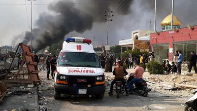 An ambulance drives past people taking part in a protest as smoke rises from a burning military truck after clashes between protesters and Iraqi policemen in Nasiriyah city, some 370km southeast of Baghdad, Iraq. EPA