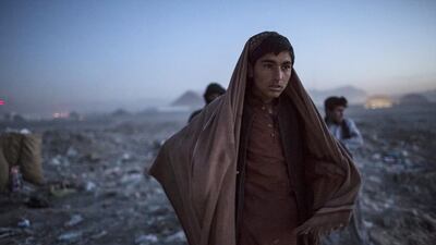 An Afghan Pashtun boy looks on as he winds up for the day after scavenging for recyclables at a garbage dump site in Kabul. Daniel Berehulak / Getty Images