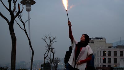 A woman holds a flare aloft during the Charshanbeh Suri fire festival, in Tehran. EPA
