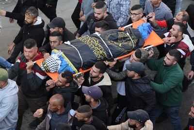 Palestinians carry one of 10 people killed in the Jenin raid during the funeral procession for the victims. AFP