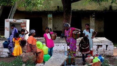 People wait to collect water during a heatwave in gauribidanur village. Jagadeesh NV / EPA