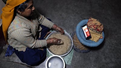 A woman watches Indian Prime Minister Narendra Modi's address to the nation on a cell phone, in Kangra, India. EPA