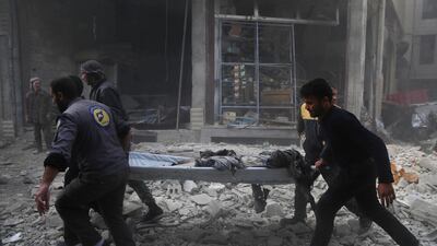 Volunteers from the White Helmets carry a victim following a reported air strike in the rebel-controlled town of Hamouria on the outskirts of the capital Damascus. AFP/Amer Almohibany