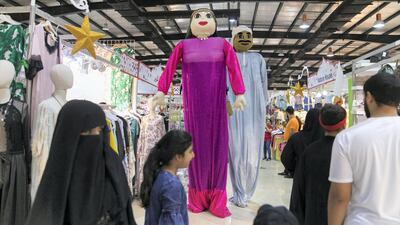 Stilt performers dressed in traditional Emirati clothes walk through the fair. Reem Mohammed / The National