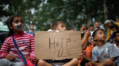A child holds up a sign as migrants stage a protest in a stadium used for traditional Kirkpinar Oil Wrestling in Edirne, Turkey. Emrah Gurel / AP Photo